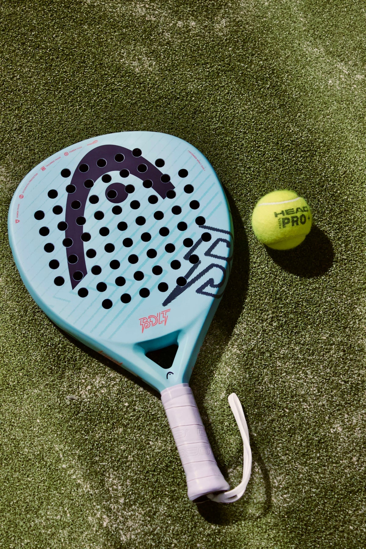 A tennis racket and a tennis ball on a court