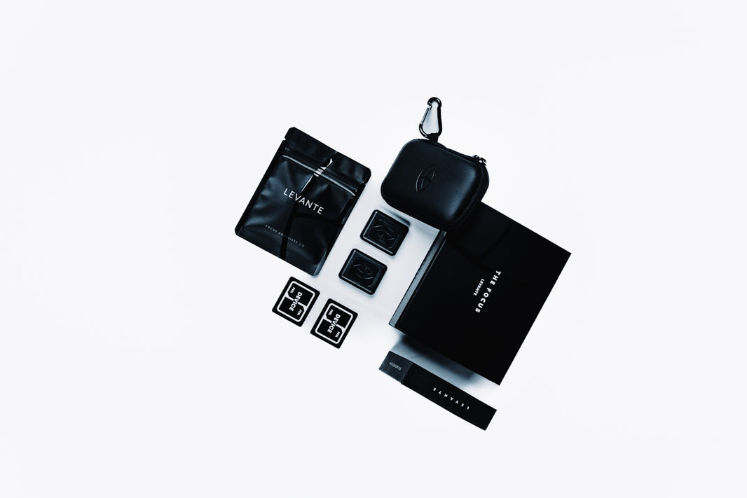 Luxury black accessories are artfully arranged on white.