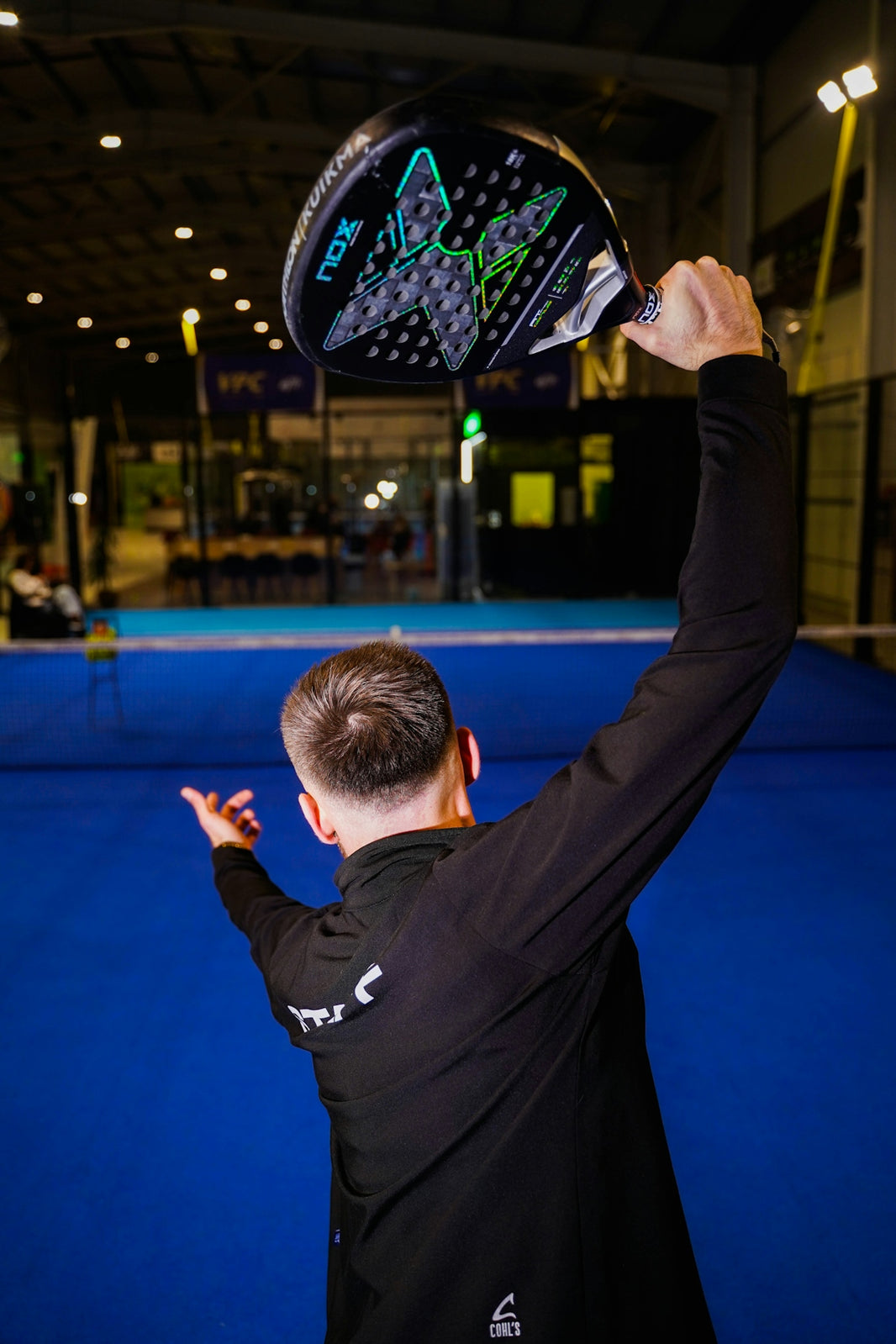 Man holding a padel racket over head