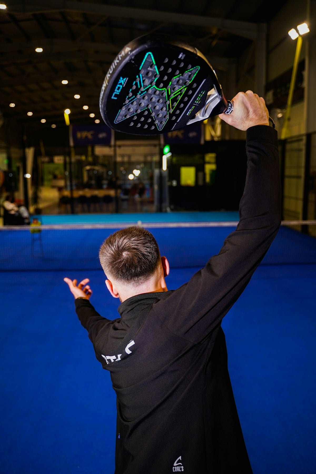 Man holding a padel racket over head