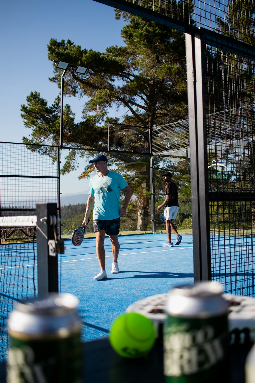 Two men playing padel tennis on a blue court